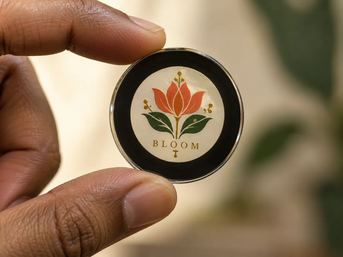 Custom glass gobo lens with the Bloom logo, held up to the light